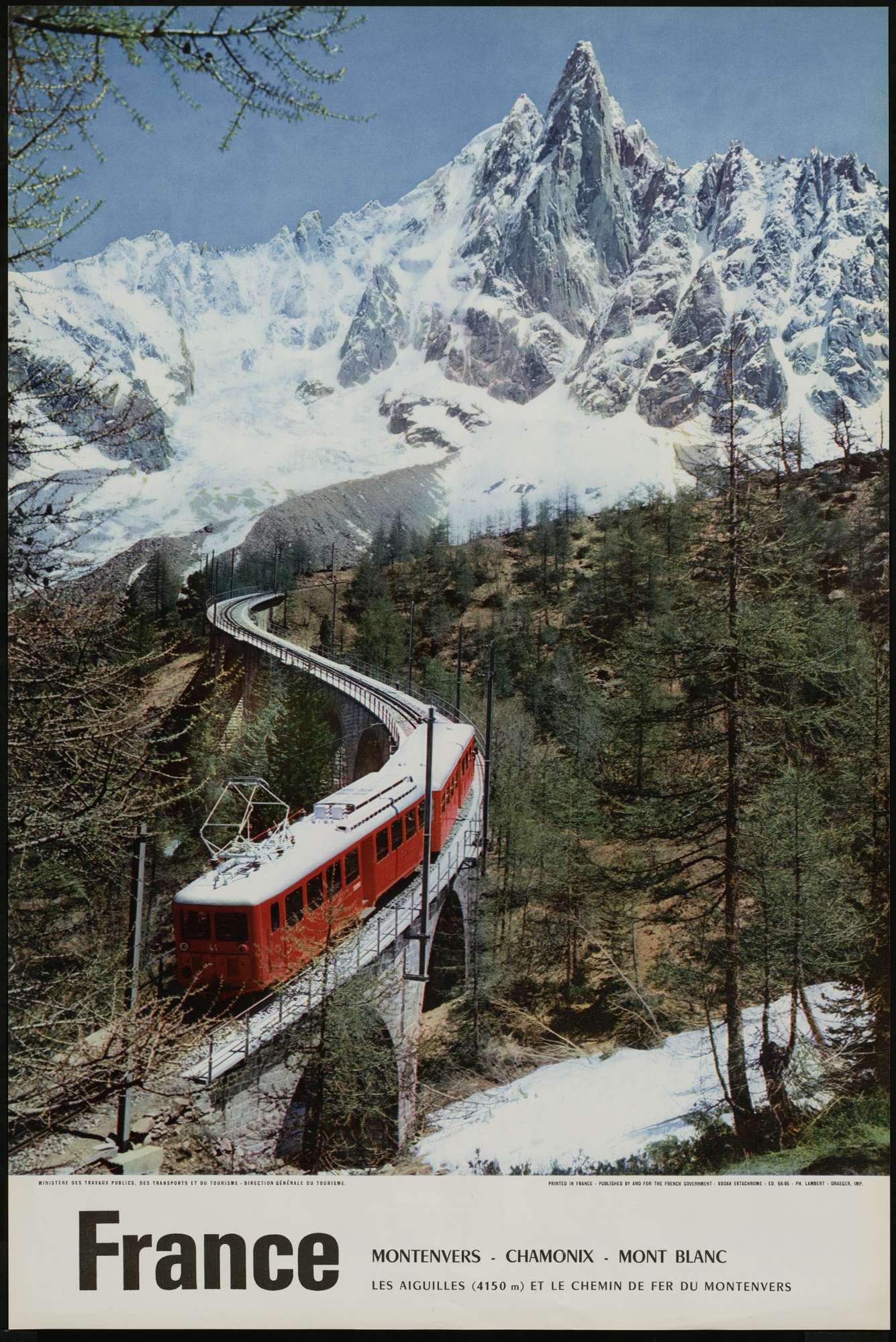 Une affiche contenant la photo d'un train rouge sur un chemin de fer vers le Mont Blanc enneigé; le mot "France" apparaît en dessous en grandes lettres capitales puis en plus petit est inscrit "le printemps en Roussillon"