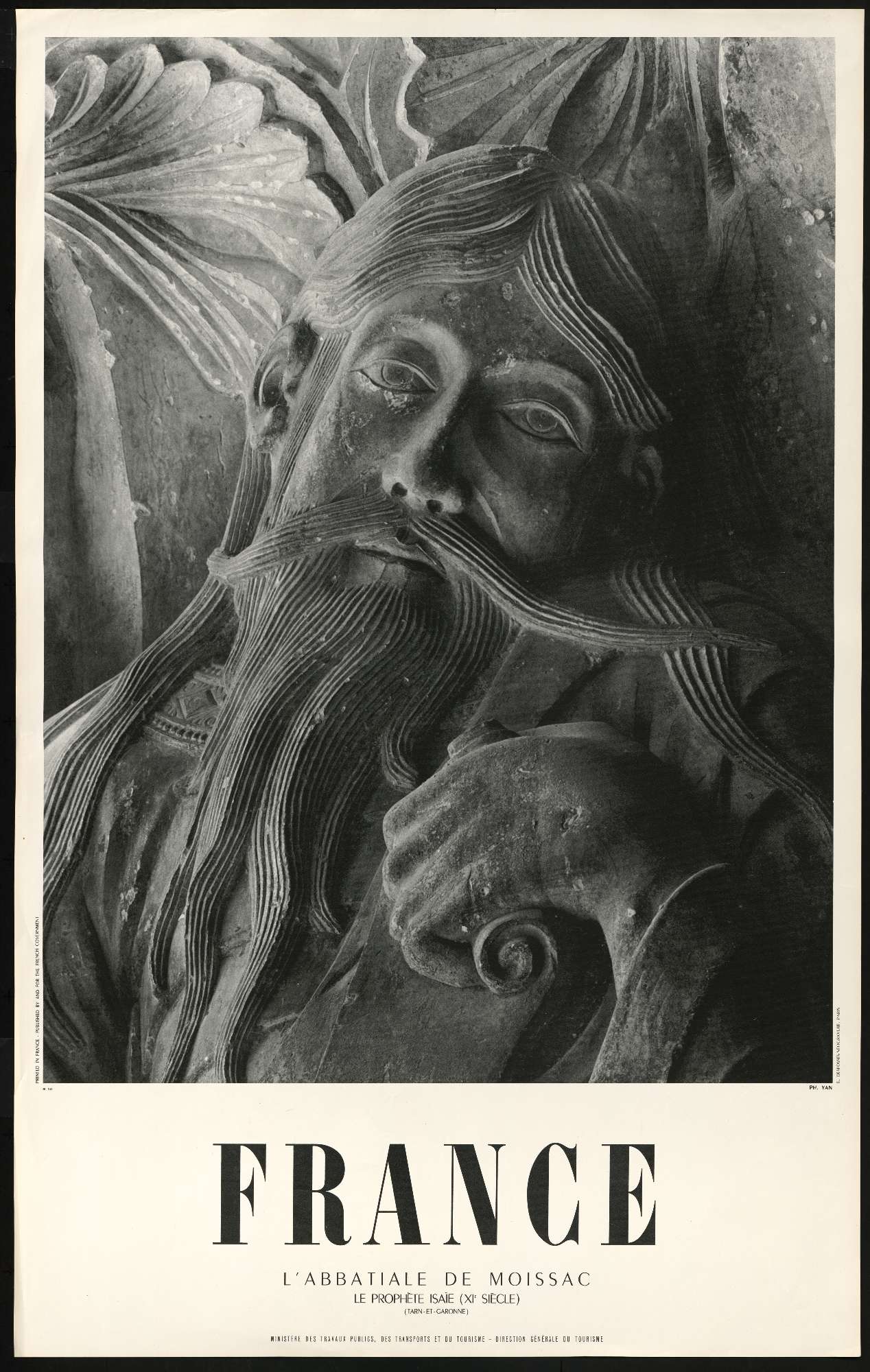 Une affiche en noir et blanc contenant la photo du visage d'une sculpture du prophète Isaïe occupe les deux tiers de l'affiche, le mot "France" apparaît en dessous en grandes lettres capitales puis en plus petit est inscrit "l'abbatiale de Moissac, le prophète Isaïe 11ème siècle, Tarn-et-Garonne, direction générale du tourisme"