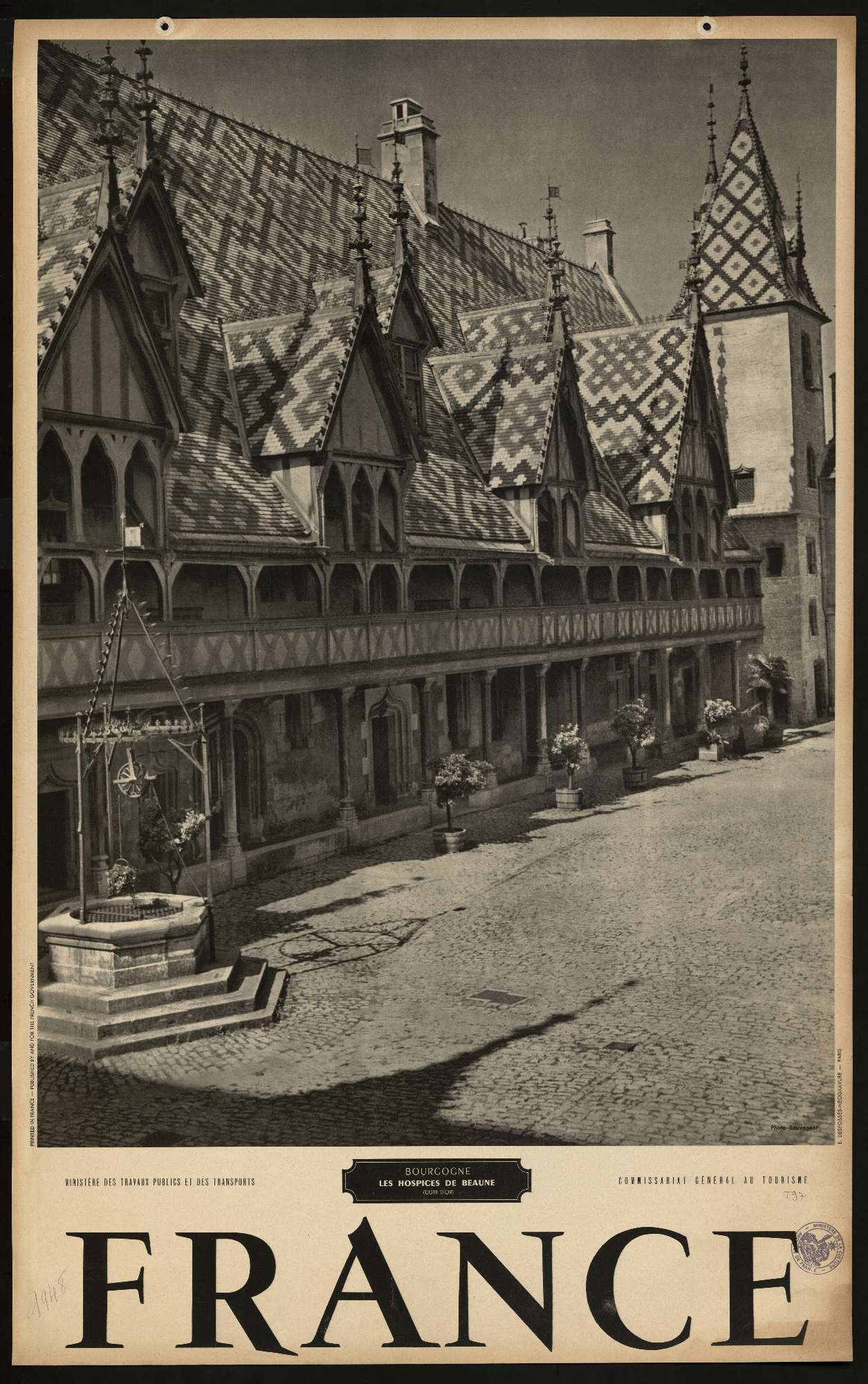 Une affiche en noir et blanc contenant la photo de la façade des hospices de Beaune occupe les deux tiers de l'affiche, le mot "France" apparaît en dessous en grandes lettres capitales puis en plus petit est inscrit "Bourgogne - les hospices de Beaune - cote d'or, commissariat général du tourisme"