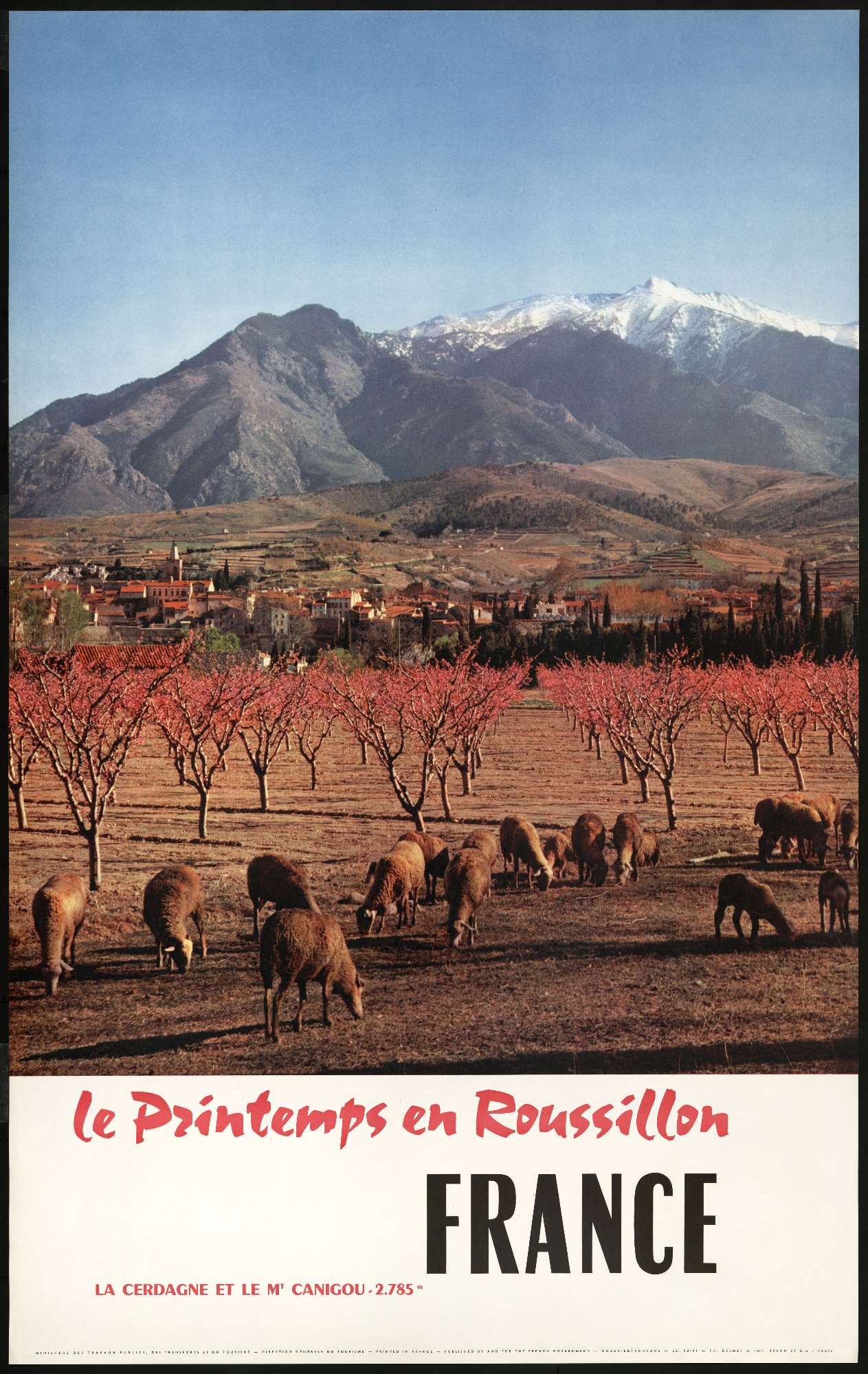 Une affiche contenantla photo de moutons qui paturent, un village, surplombé d'une montagne enneigée; le mot "France" apparaît en dessous en grandes lettres capitales puis en plus petit est inscrit "le printemps en Roussillon"