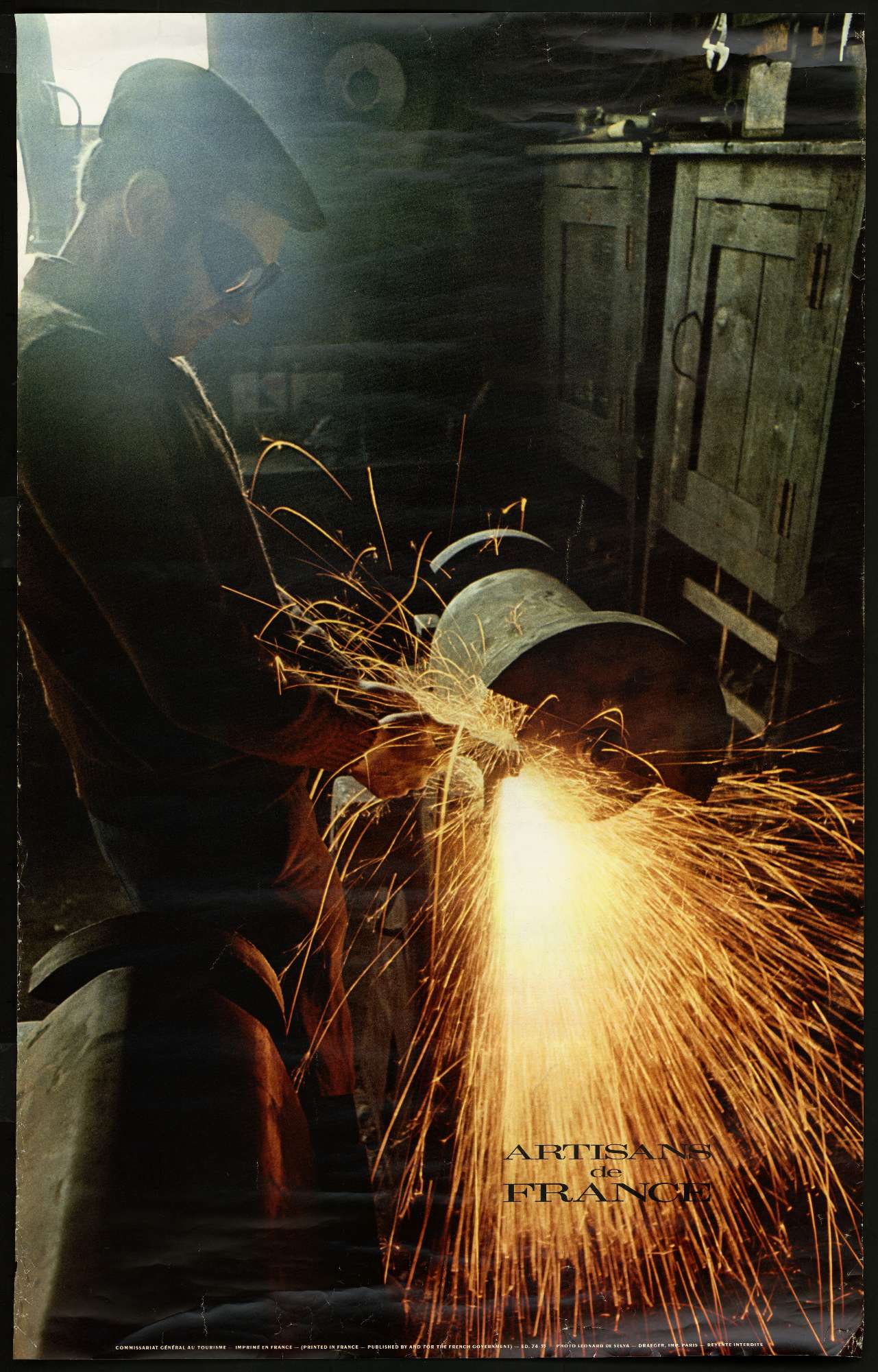 Une affiche contenant une photo d'un homme entrain de meuler; le mot "France" apparaît en dessous puis en plus petit est inscrit "Artisans de France"