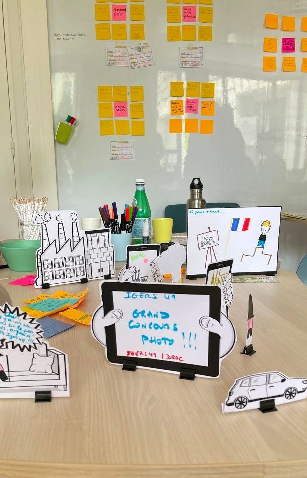 Photo de prototypes d'une interface numérique sur des wireframe papier